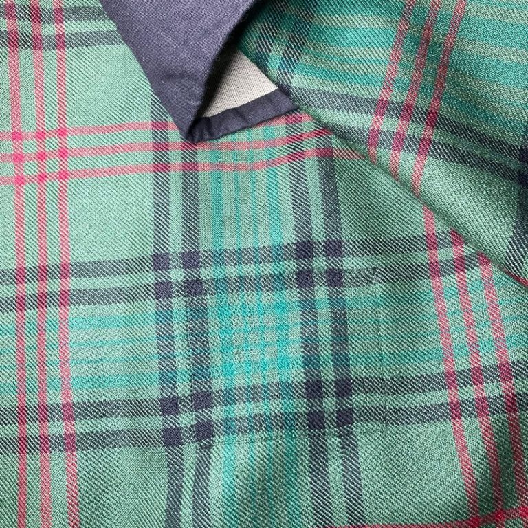 Invisible mending on torn tartan - Glasgow kilt repair Close-up of invisible mending repair on damaged repair on damaged tartan kilt fabric - Glasgow kilt restoration service